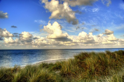 Wasser, Wolken und Dünen lassen sich bei einem Sylt-Urlaub zu beeindruckenden Fotos komponieren. Hobbyfotografen können ihre besten Aufnahmen anschließend anderen Fans der Nordseeinsel präsentieren. Foto: djd/Kurverwaltung List/M.Koch