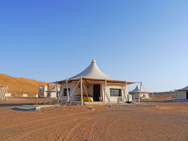 Camp in der Wüste Wahiba Sands: Für den Sonnenuntergang kann man auf eine einsame Düne klettern, um das einzigartige Farbenspiel bei absoluter Ruhe zu genießen. Foto: djd/Abendsonne Afrika