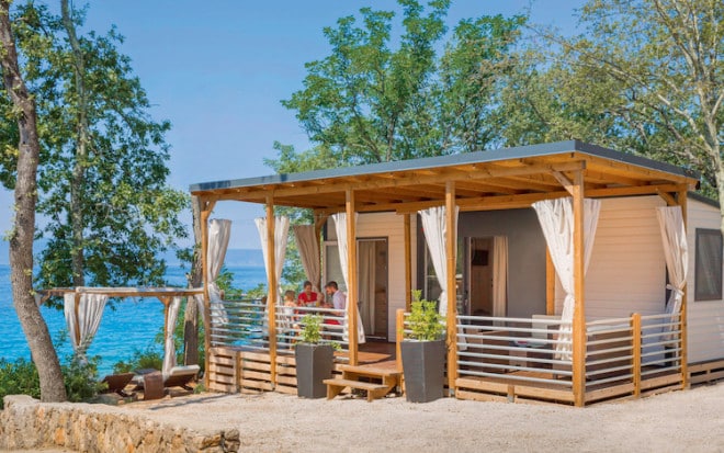 Urlaubsidylle pur: Am Rande des Zeltplatzes gelegen, bildet das Mobilheim mit eigener Terrasse einen kleinen privaten Rückzugsort, an dem sich herrlich entspannen lässt. (Foto: epr/I.D. Riva Tours)