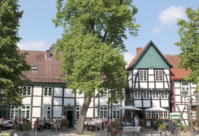 Kleines Haus, altes Fachwerk, großer Genuss: Am Kirchplatz in Bad Essen servieren zahlreiche Gastgeber saisonale und regionale Genüsse. Foto: Tourist-Info Bad Essen