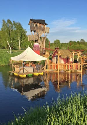 Über die schwimmende Wanderbrücke gelangt man zu dem auf dem Grenzfluss treibenden Neiße-Café. Foto: djd/Kulturinsel Einsiedel